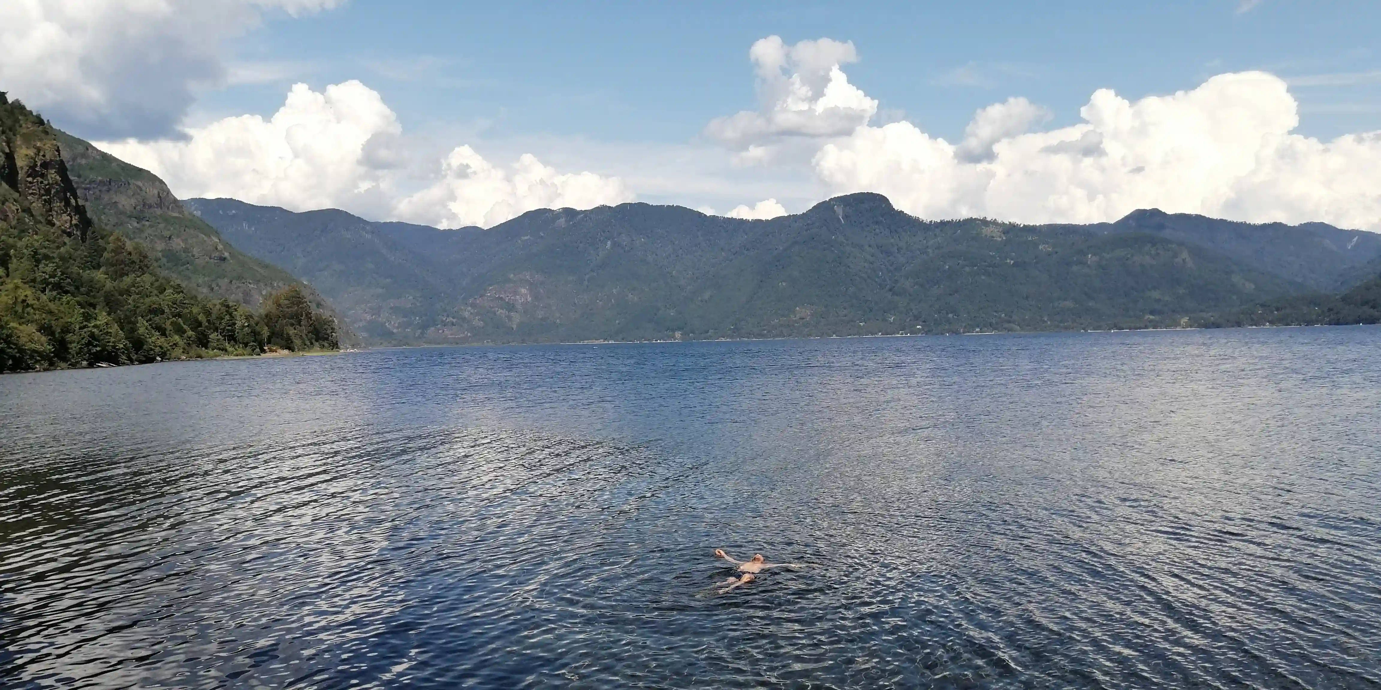 Andean lake surrounded by native forest and volcanoes in La Araucanía, Chile